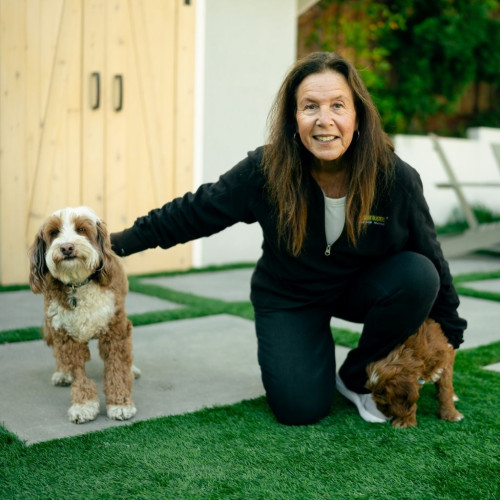 Dog trainer with two puppies in the backyard