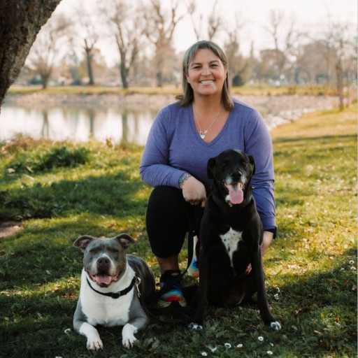 Woman walking her two dogs by a lake