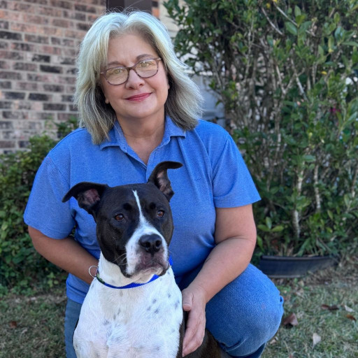 Woman kneels outside with her dog