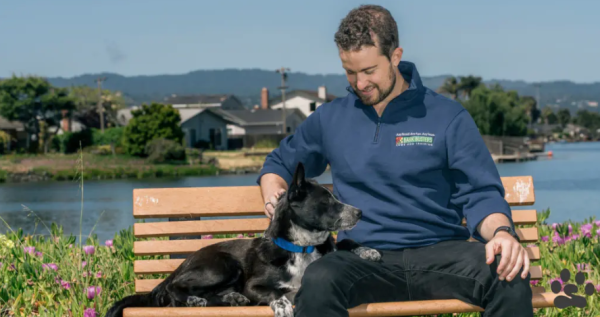 Bark Busters dog trainer on a park bench with his dog