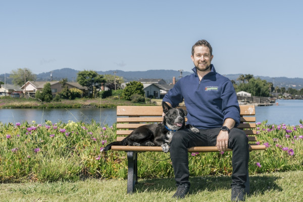 Dog trainer in San Mateo with his dog on a park bench