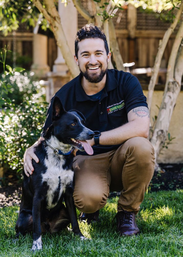 Happy dog and dog trainer in a sunny garden