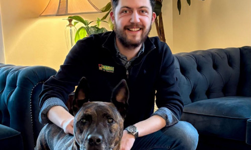 Bark Busters dog trainer in a living room with a dog