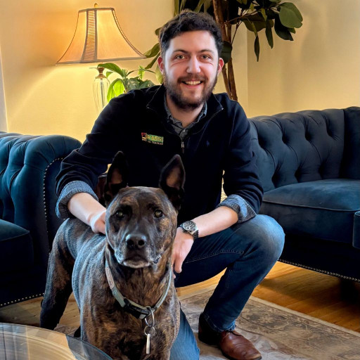 Bark Busters dog trainer in a living room with a dog