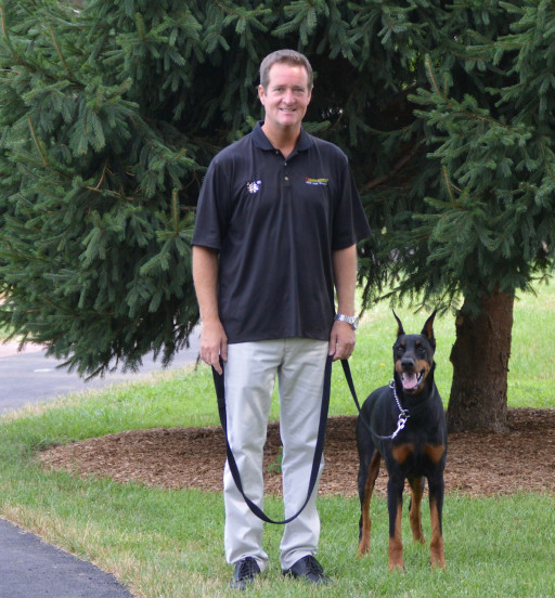 Professional dog trainer during home dog training session with doberman