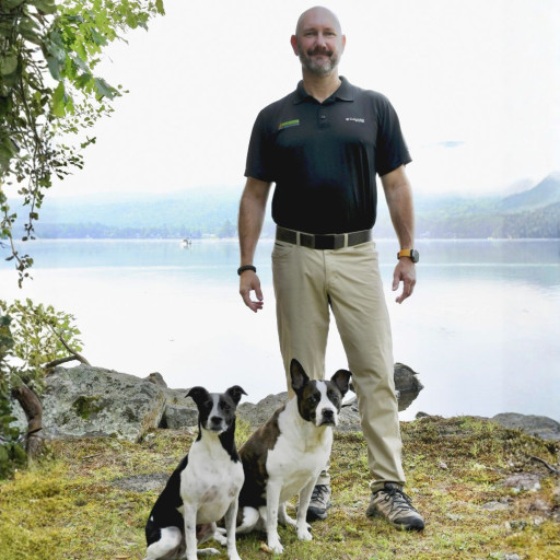 Dog trainer standing outdoors with his two dogs