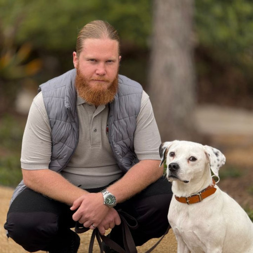Dog trainer takes a walk in the park with his dog